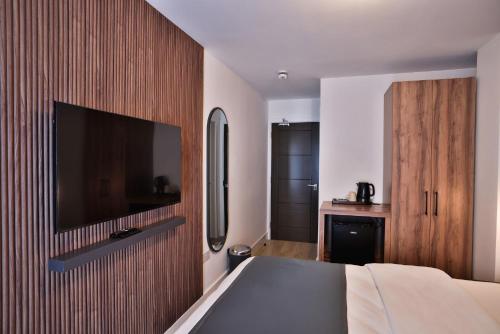 a bedroom with a television on a wooden wall at Finsbury Rose in London