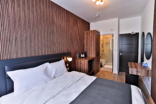 a bedroom with a large bed and a bathroom at Finsbury Rose in London