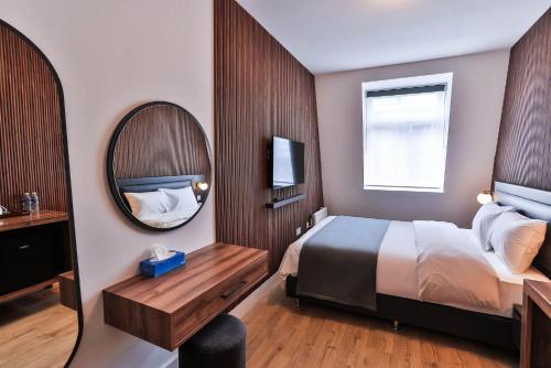 a hotel room with a bed and a mirror at Finsbury Rose in London