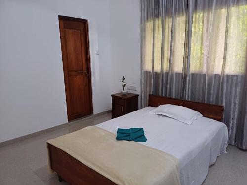 a bedroom with a bed with a blue bow on it at Yelona Rest in Galle