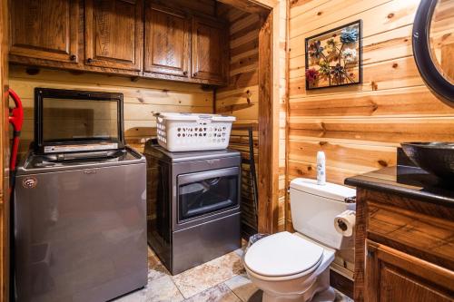 a kitchen with a stove and a toilet in a cabin at Time Well Wasted in Stephens Gap