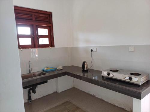 a kitchen with a sink and a stove at Yelona Rest in Galle
