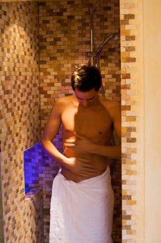 a man standing in a shower in a bathroom at Apart Hotel Garni Strasser in Zell am Ziller