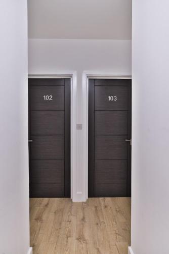 a row of three garage doors with numbers on them at Finsbury Rose in London