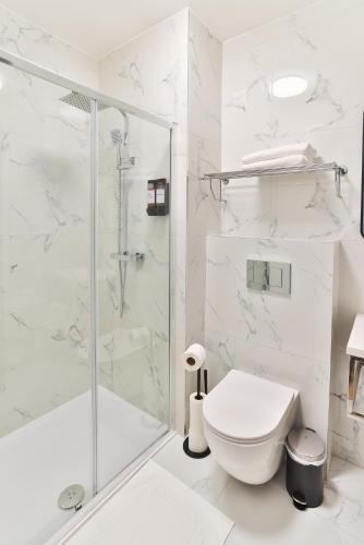 a white bathroom with a shower and a toilet at Finsbury Rose in London