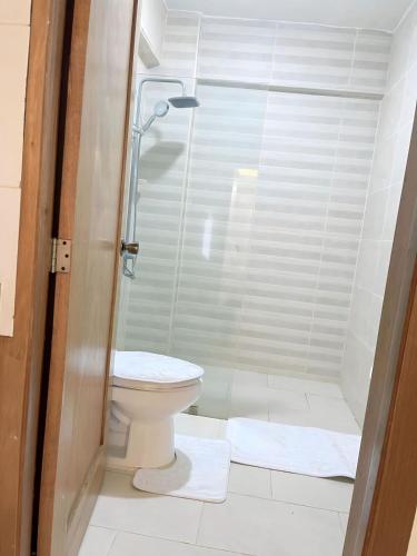 a bathroom with a shower and a toilet with towels at Villa súper cómoda 3 habitaciones con piscina in Juan López