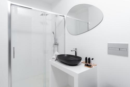 a bathroom with a sink and a mirror at Frati Villas Beachfront in Perivolos
