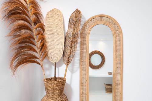 a vase with feathers in front of a mirror at Frati Villas Beachfront in Perivolos