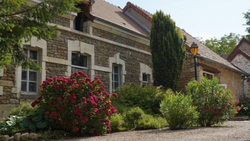 a brick house with flowers in front of it at Domaine Les Bertrands in Couches