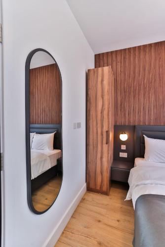 a bedroom with a mirror and two beds in it at Finsbury Rose in London