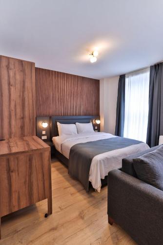 a bedroom with a large bed and a couch at Finsbury Rose in London