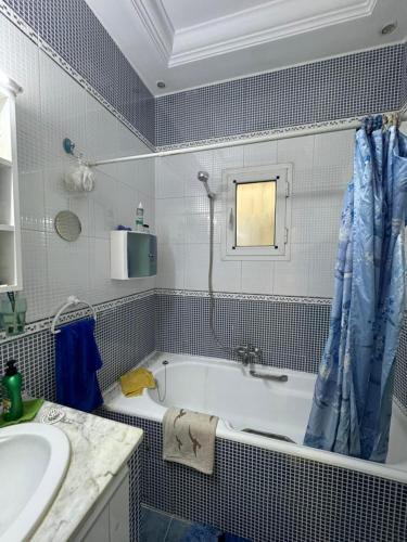 a bathroom with a bath tub and a sink at Appart Campus in Ibn Khaldoun