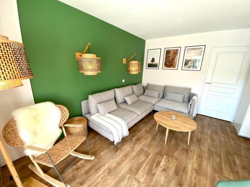 a living room with a couch and a table at Le Cottage de Belle Dune in Fort-Mahon-Plage