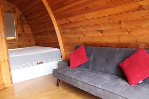 a couch with two red pillows sitting in a room at Quinta da Devesa -B2 in Vinhais