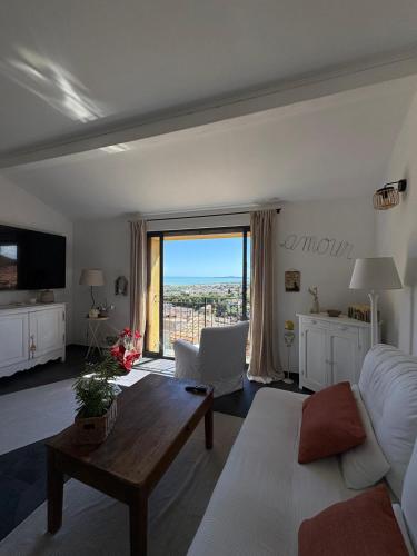 un salon avec un canapé et une table dans l'établissement Maison de village avec vue magnifique, à Cagnes-sur-Mer