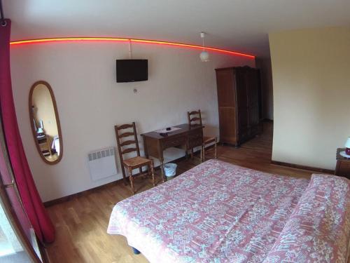 a bedroom with a bed and a table and a mirror at Boustigue Hotel in Corps