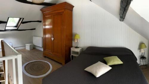 - une chambre avec un lit noir et une armoire en bois dans l'établissement Le Courtil de Grammont, à La Celle-sous-Gouzon