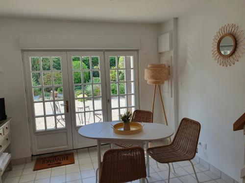 une salle à manger avec une table et des chaises blanches dans l'établissement Le Courtil de Grammont, à La Celle-sous-Gouzon