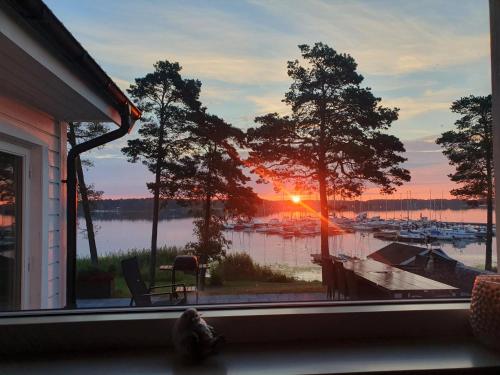 a window with a view of a marina at sunset at Modernt fritidshus med havsutsikt Mönsteråsviken in Mönsterås