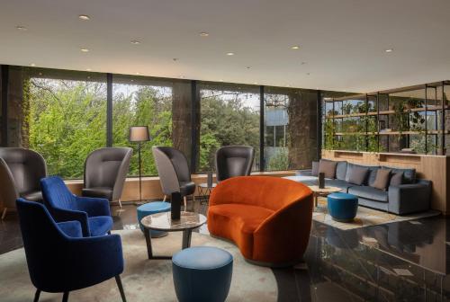 a lobby with chairs and a couch and tables at Crowne Plaza Milan Linate by IHG in San Donato Milanese