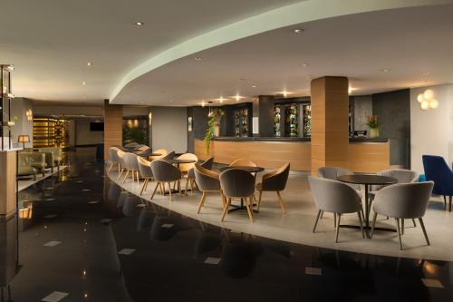 a restaurant with tables and chairs in a lobby at Crowne Plaza Milan Linate by IHG in San Donato Milanese