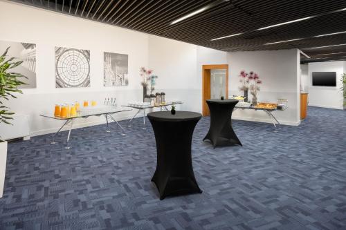a room with two tables with flowers on them at Crowne Plaza Milan Linate by IHG in San Donato Milanese