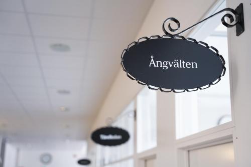 a black sign that reads ayvalian hanging in a building at Home Hotel Bolinder Munktell in Eskilstuna