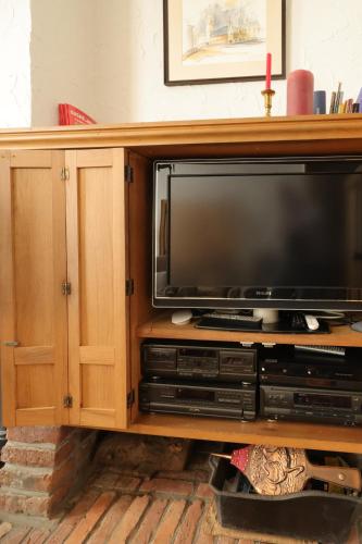 a entertainment center with a large television in it at In De Wulf in Ypres