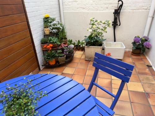 a blue chair sitting on a patio with potted plants at In De Wulf in Ypres