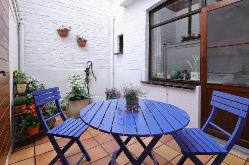 a blue table and two chairs on a patio at In De Wulf in Ypres