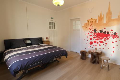 a bedroom with a bed and a painting on the wall at In De Wulf in Ypres