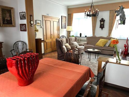 a living room with a table and a couch at In De Wulf in Ypres