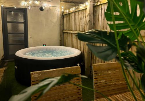 a large bath tub in a room with a plant at Duplex Stay With Hot Tub Opposite Stadium in Cardiff
