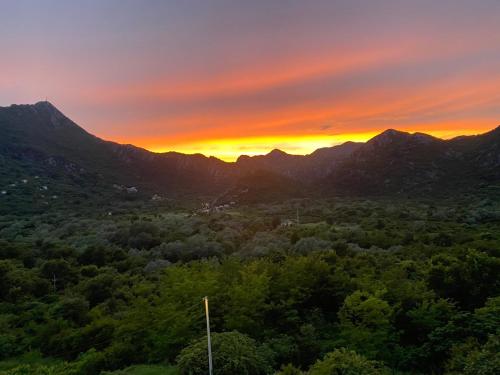 a sunset over a valley with mountains and trees at Brioni in Virpazar