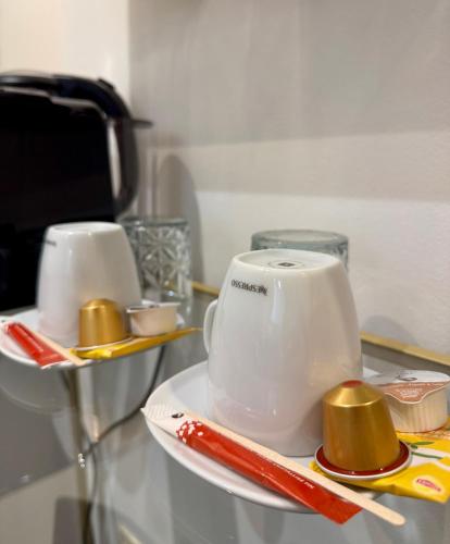 two white cups sitting on a glass table at Hotel de Maître de Vaughan in Brussels