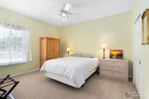 a bedroom with a bed and a ceiling fan at Stay ON Flagler Avenue! Charming Condo with Full Kitchen, Parking and Courtyard! in Chicken Island