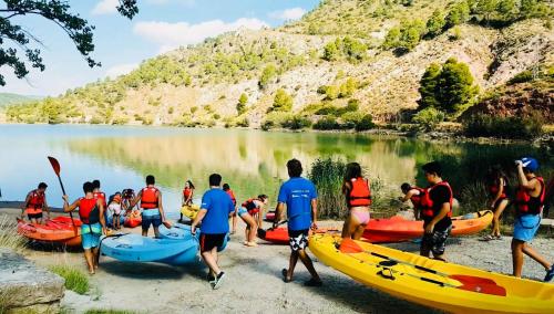 a group of people standing on a beach next to a lake at Ignis Rural Apartment - Casillas Valle de Ayora in Jalance