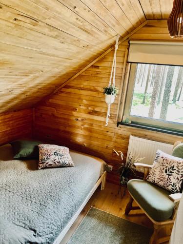 a bedroom with a bed and a window in a room at Piparmētras in Mērsrags