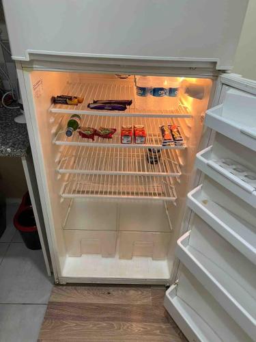 an empty refrigerator with its door open with food items at Cozy Apartment Near Oldtown Antalya in Antalya