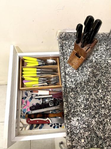 a drawer full of knives and utensils on a counter at Cozy Apartment Near Oldtown Antalya in Antalya