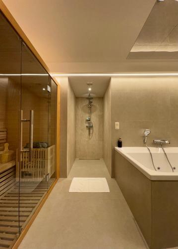 a bathroom with a tub and a walk in shower at Hotel de Maître de Vaughan in Brussels