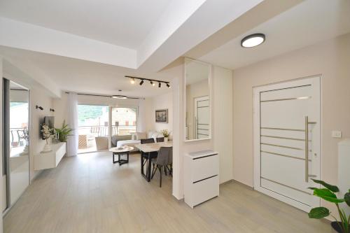 a kitchen and dining room with a table and a door at SEA VIEW apartment 2km from the Old Town of Kotor in Dobrota