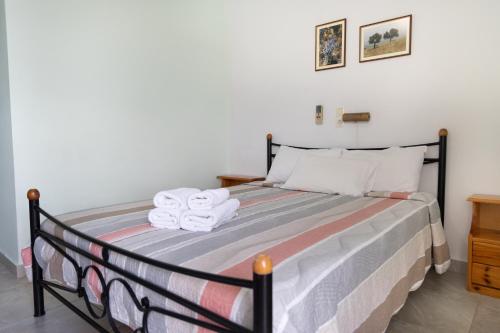 a bedroom with a bed with towels on it at Panorama Rooms in Pirgos Dhirou