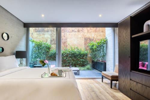 Un dormitorio con una cama y una ventana grande. en AR 218 Hotel by ULIV, en Ciudad de México