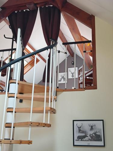 a wooden staircase in a house with curtains at L'Escale Gourmande in Hatrival