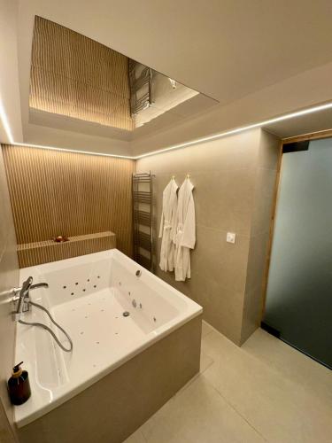 a bathroom with a large tub and a sink at Hotel de Maître de Vaughan in Brussels
