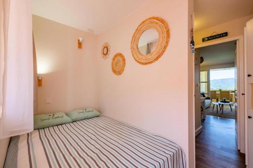 une chambre avec un lit et un miroir au mur dans l'établissement Résidence le Village de Cap Esterel - maeva Home - Studio 4 personnes - Sélection MAE-3501, à Saint-Raphaël