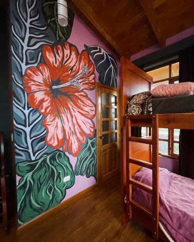 a bedroom with a mural of a flower on the wall at Hoppy Alpaca in Cotacachi
