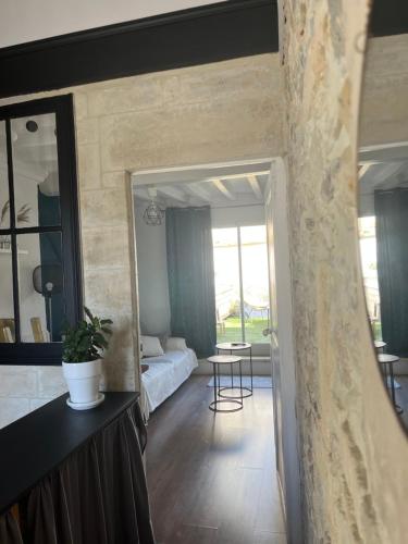 - un salon avec un lit et un miroir dans l'établissement Maison de ville avec terrasse, à Bayeux