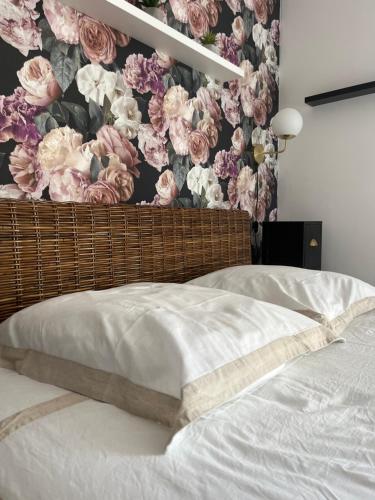 - une chambre avec un papier peint floral sur le mur dans l'établissement Maison de ville avec terrasse, à Bayeux